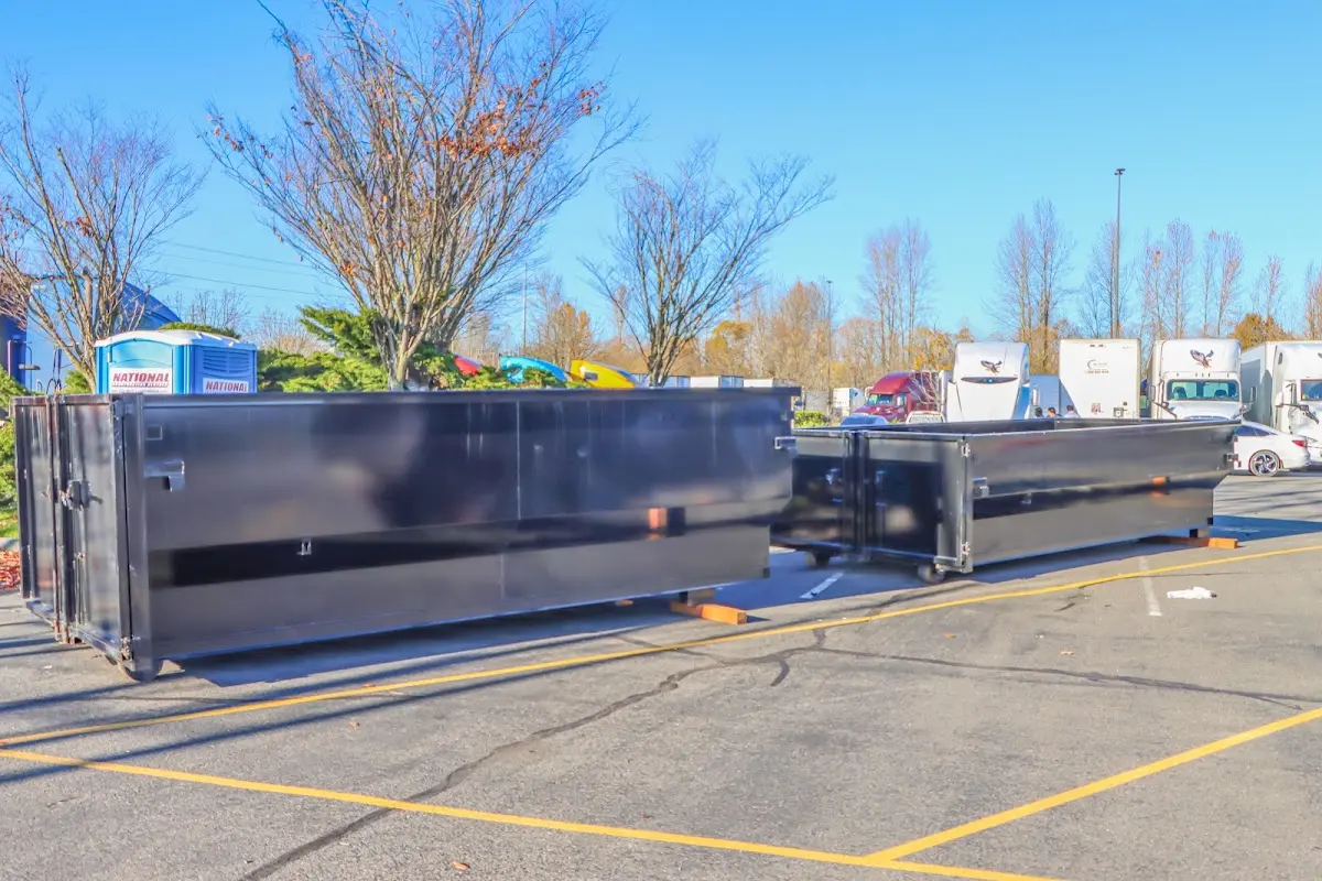 Professional dumpster rental service with roll-off container on residential driveway in Woodland Park